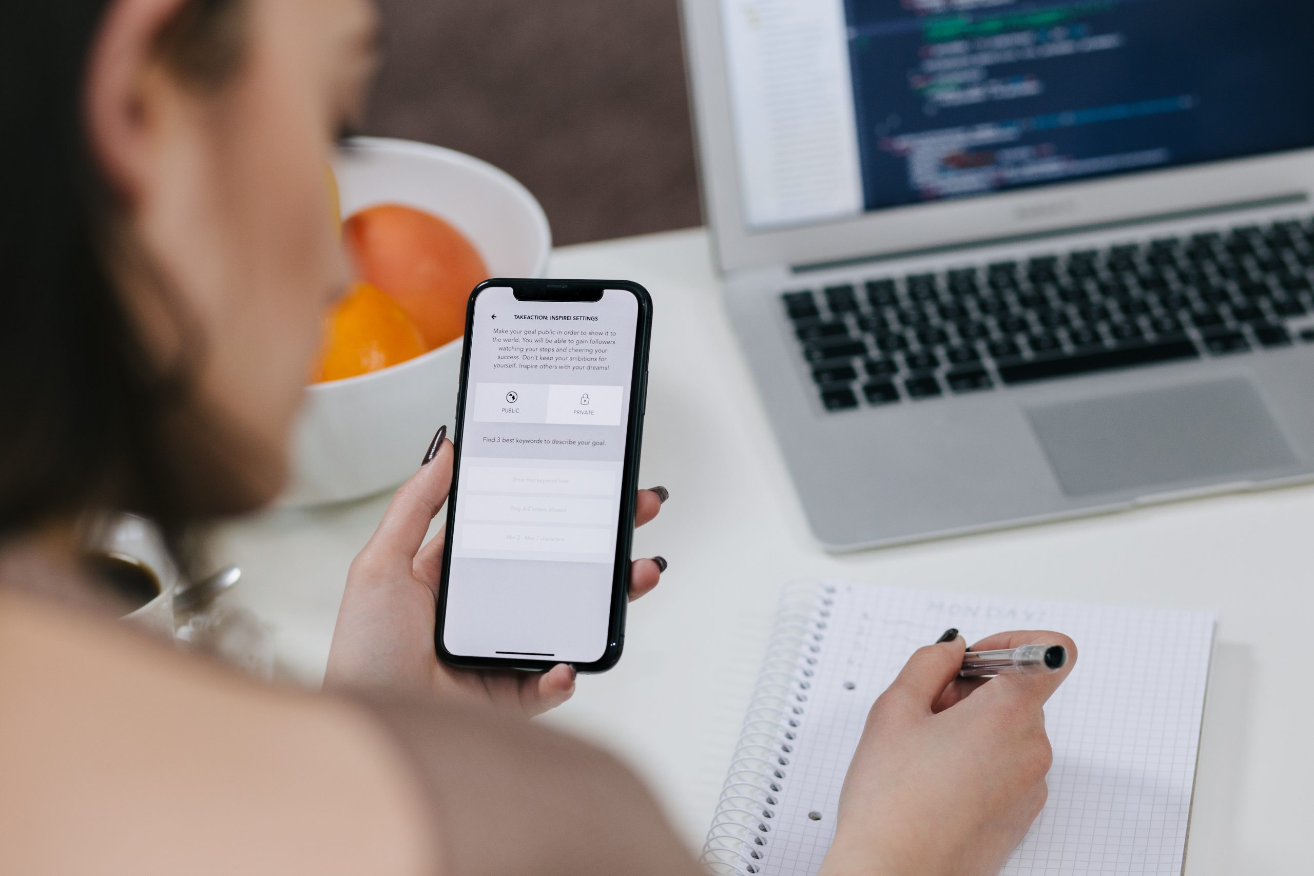 Girl Using a Phone While Writing Notes on a Notebook