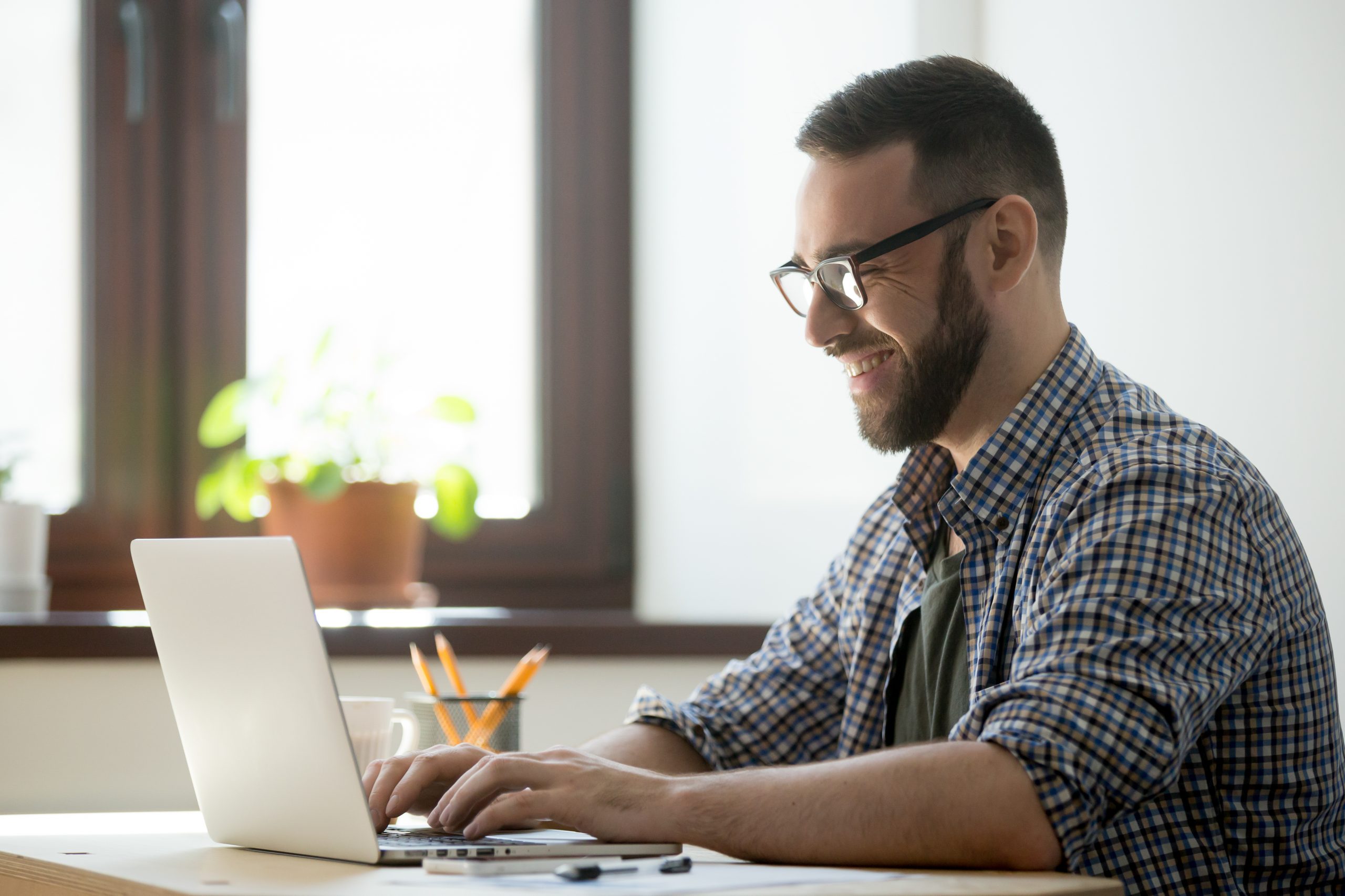 a male employee moderating on an online focus group discussion in front of his laptop