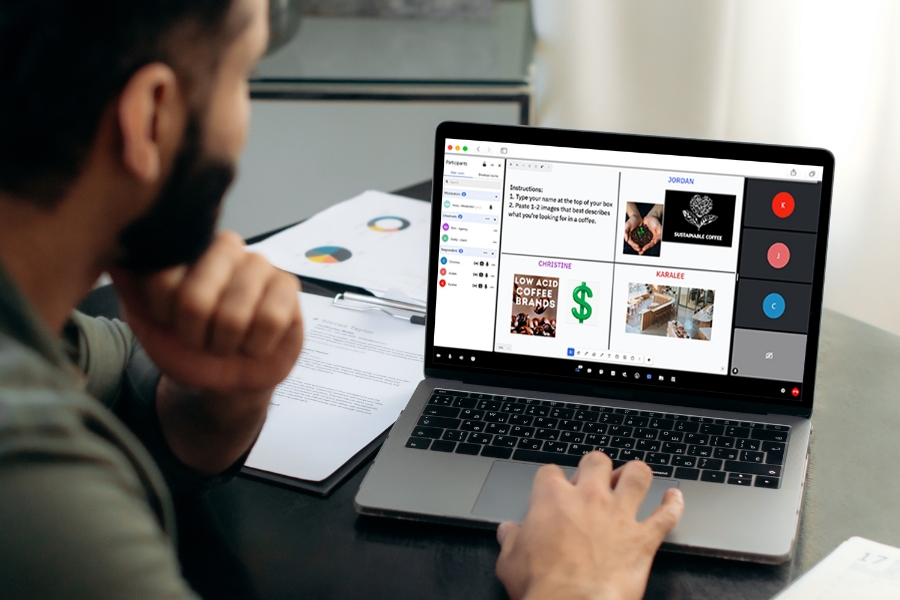A man operating a laptop, with a video visible on the screen in front of him.